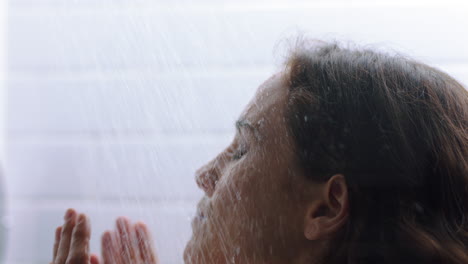 mujer atractiva tomando una ducha tocando la piel húmeda disfrutando de un spa de lujo sensual limpiando el cutis suave