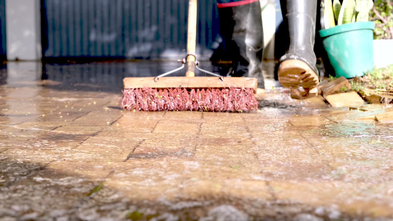 Rainwater threatening to flood garage of home being swept off driveway, frontal