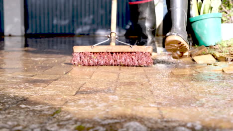 rainwater threatening to flood garage of home being swept off driveway, frontal
