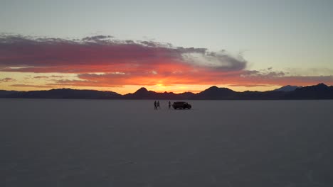 adventurers enjoy epic sunset colors at bonneville salt flats utah aerial reverse dolly