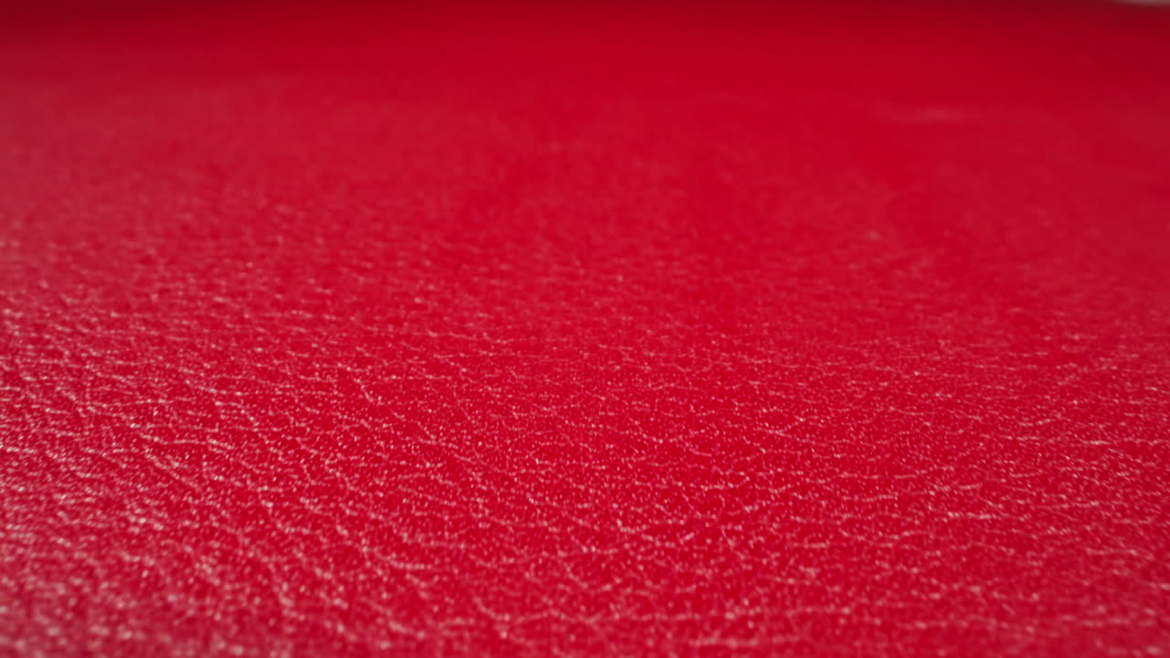 Crimson color cow leather material as background macro view