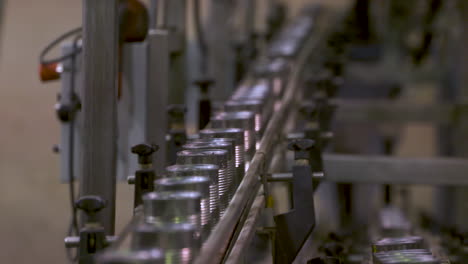 aluminum cans move along a conveyor track at a food packaging factory