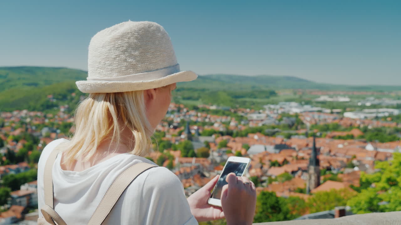 turista con smartphone frente a ciudad alemana