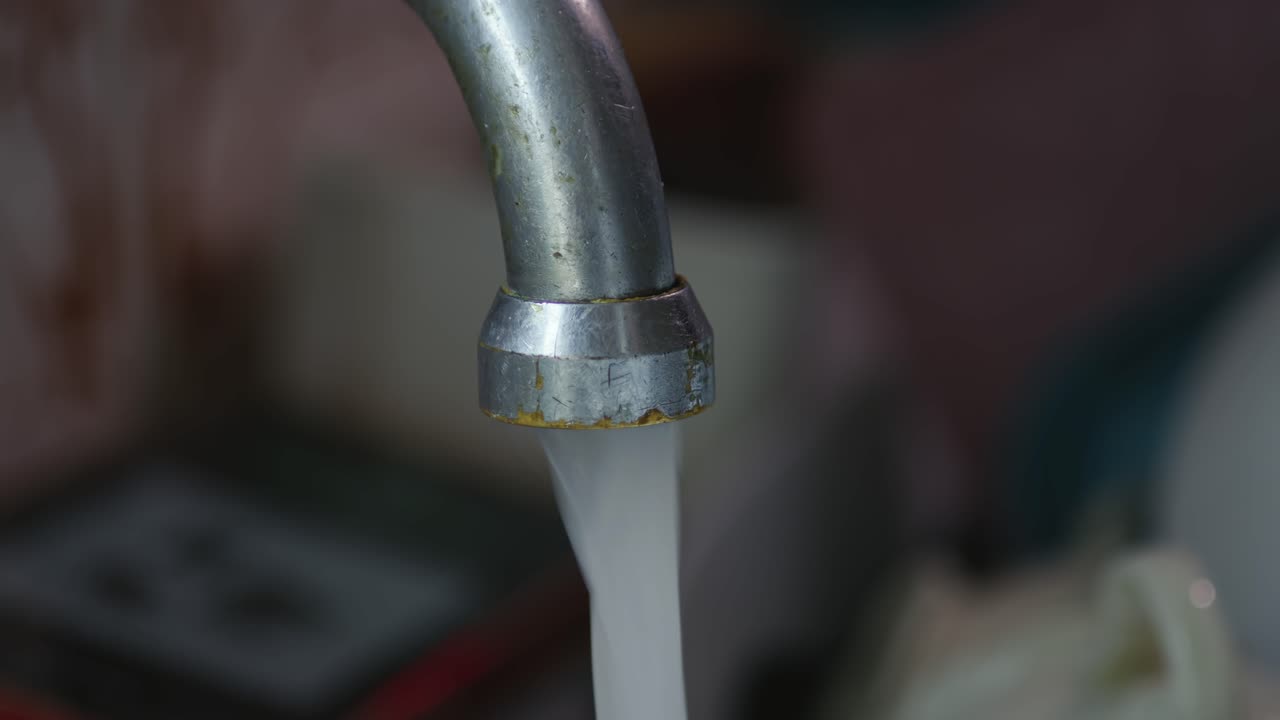 Close-up of water flowing from Kitchen tap from gush, trickle, to drips