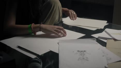 An individual is seen with papers and a pen, gearing up for sketching, symbolizing the inception of an inspirational drawing journey