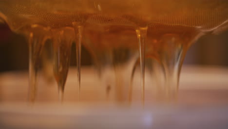 process of straining thick honey