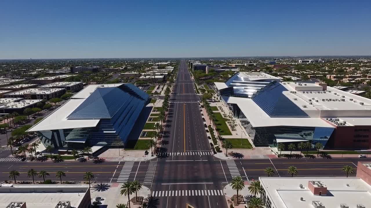 Aerial view of modern architecture showcasing sleek glass buildings flanking a wide, empty street, capturing the essence of urban design and open space