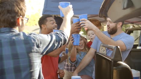 slow motion shot of sports fans tailgating in parking lot