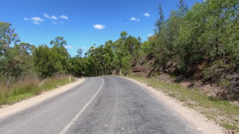 punto de vista de conducción mirando hacia atrás de una carretera rural de queensland seca y polvorienta desierta con árboles de goma y bancos rocosos: ideal para el reemplazo de la pantalla verde de la escena interior del automóvil