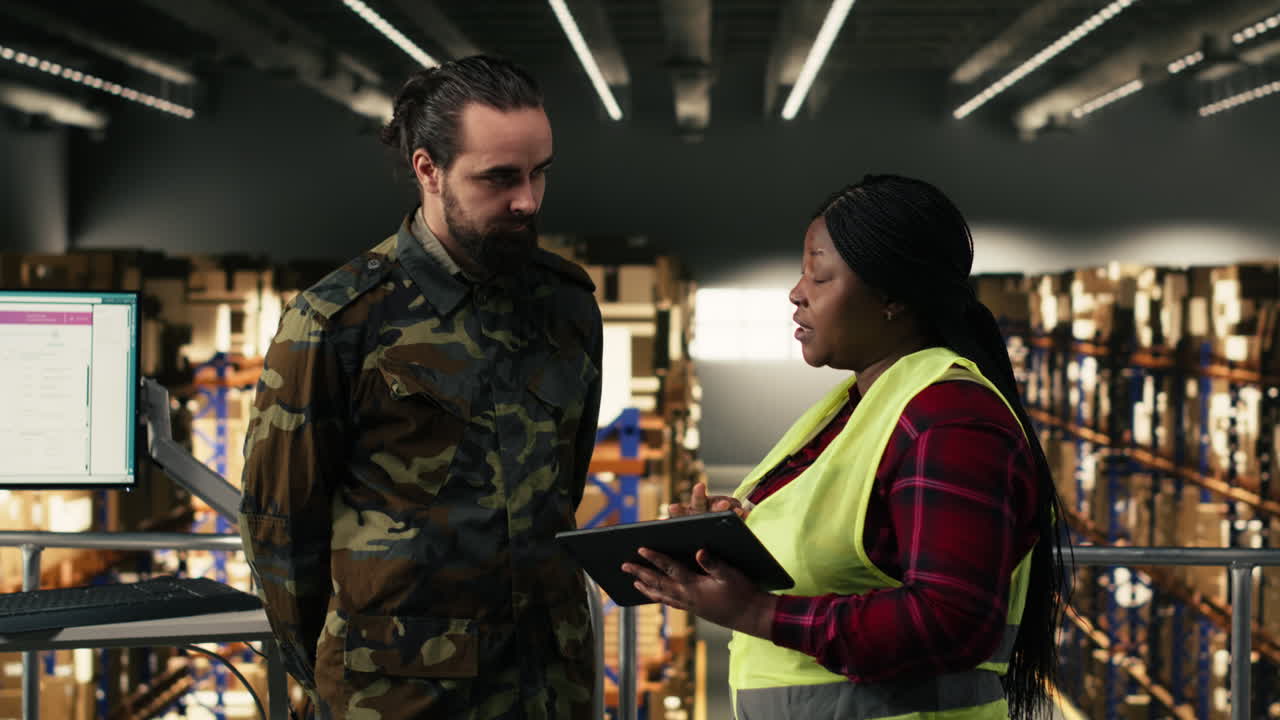 Lavoratori di magazzino che discutono dell'inventario su tablet digitale