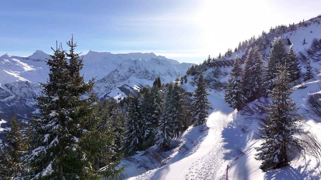 rastro de pasos sobre un sendero de montaña nevado en un brillante día soleado de invierno en adelboden