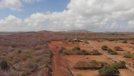 Una-Antena-De-Una-Granja-De-Avestruces-En-La-Isla-De-Curacao-Con-La-Playa-Y-Las-Montañas-Al-Fondo