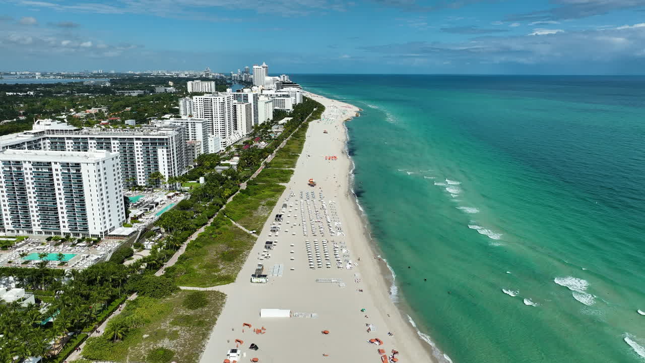 Una vista aérea cinematográfica con dron del 1 Hotel Miami Beach muestra su complejo frente a la playa, el océano turquesa y el diseño costero moderno