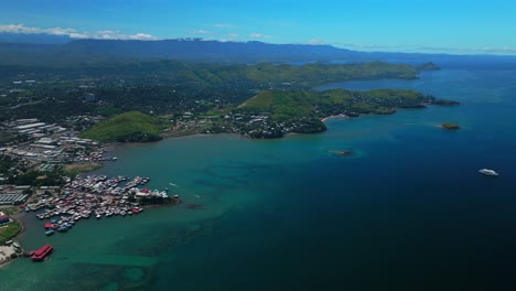 Walter-Bay-fish-market-Port-Moresby-Papua-New-Guinea-aerial-drone-capital-city-Harbour-Marina-PNG-beautiful-sunny-blue-sky-morning-islands-Ela-Beach-Crown-Hotel-Plaza-Hilton-Coral-Sea-backward