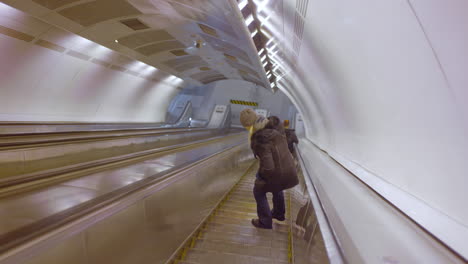 person riding an escalator in a modern subway station