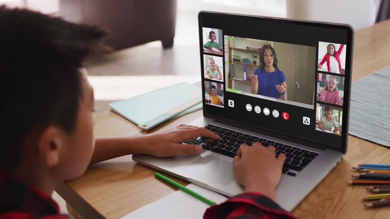 escolar que usa una computadora portátil para una lección en línea en casa, con un maestro y una clase diversos en la pantalla