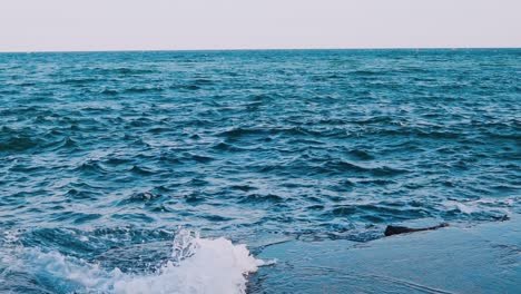 waves crashing on stone beach. amazing view of sea water. blue water surface. beautiful motion of sea water. slow motion.