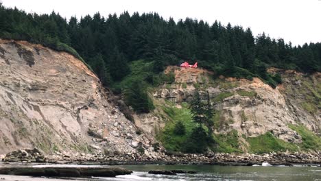 coast guard man dangles from helicopter before being lowered to save an injured hiker