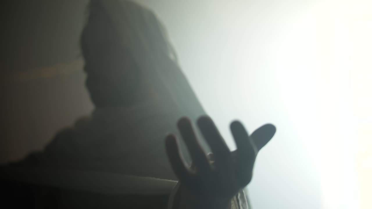 The resurrection of Jesus Christ inside the tomb, in bright light, raising his hands in dramatic, cinematic slow motion. Perfect for Easter resurrection visual.