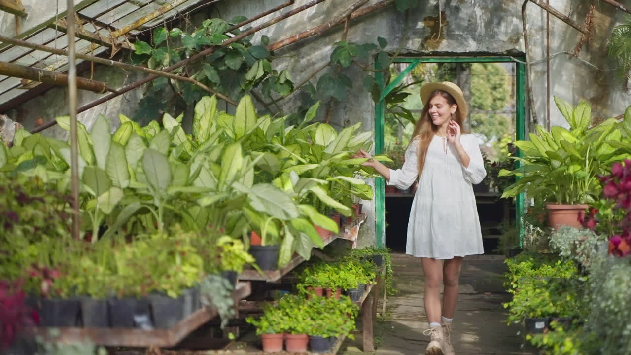 mujer explorando un invernadero lleno de plantas