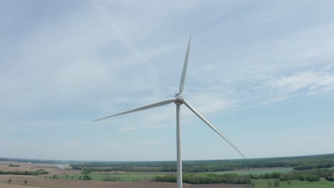 Aspas-De-Molino-De-Viento-Giratorias-Contra-El-Cielo-Azul-Pálido-Con-Nubes-Suaves-Y-Delgadas-Vistas-Desde-Drones-En-órbita