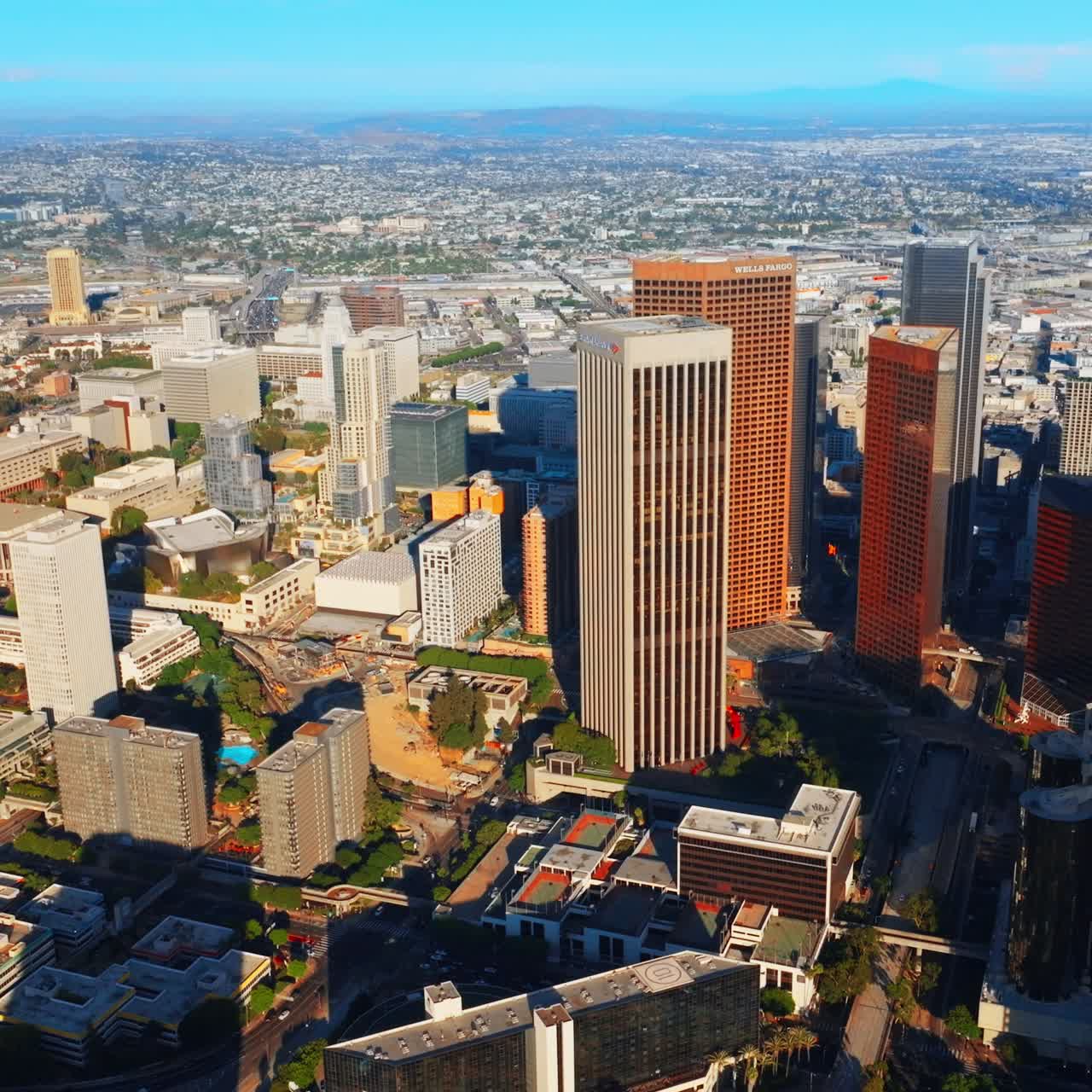 Financial downtown of sunny Los Angeles. Diverse skyscrapers and multi-storied buildings in the city centre. Urban scenery at backdrop. Top view