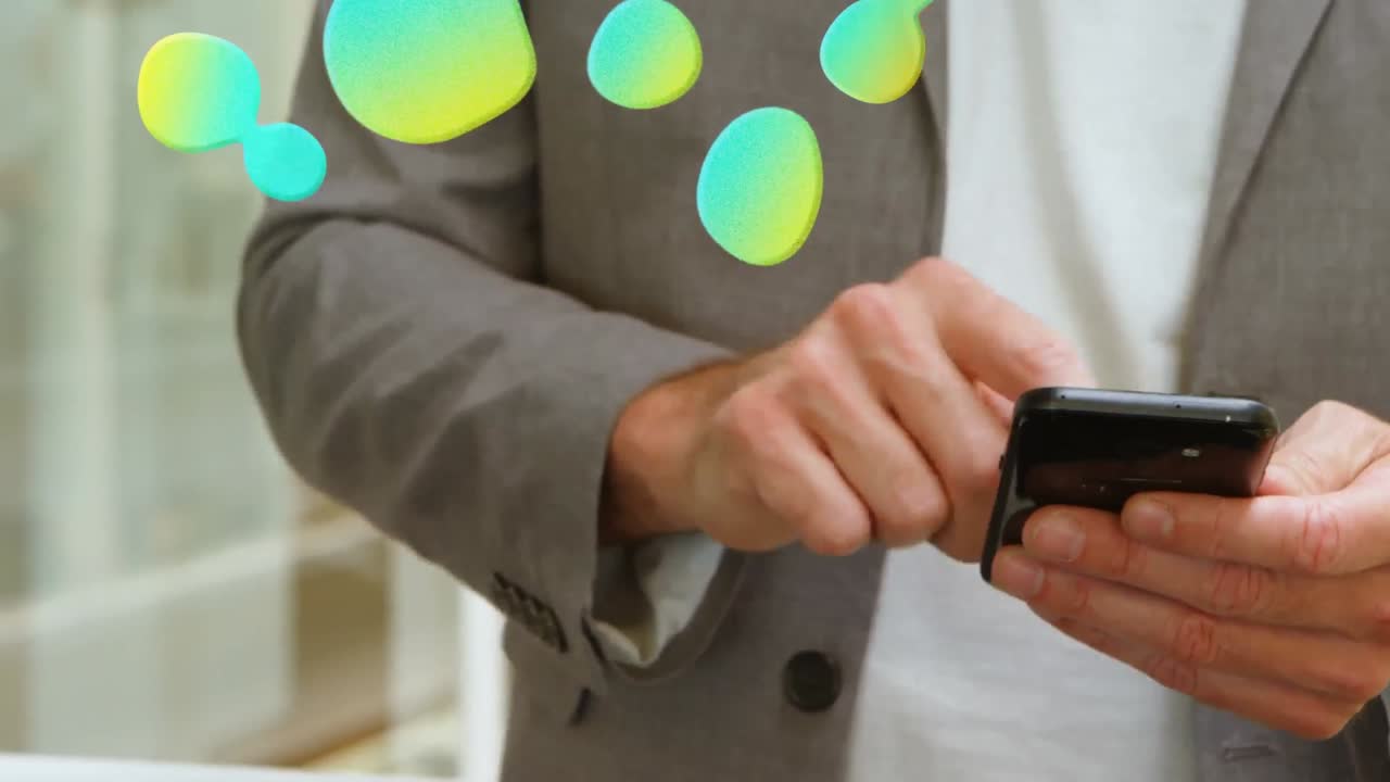 animación de manchas sobre un hombre de negocios caucásico usando un teléfono inteligente