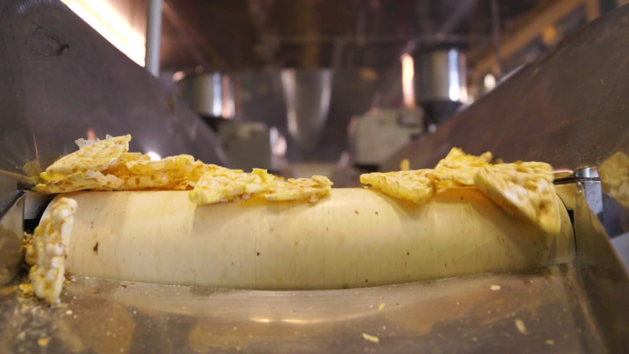 disparo de un transportador en movimiento y chips de maíz cayendo desde el extremo de él