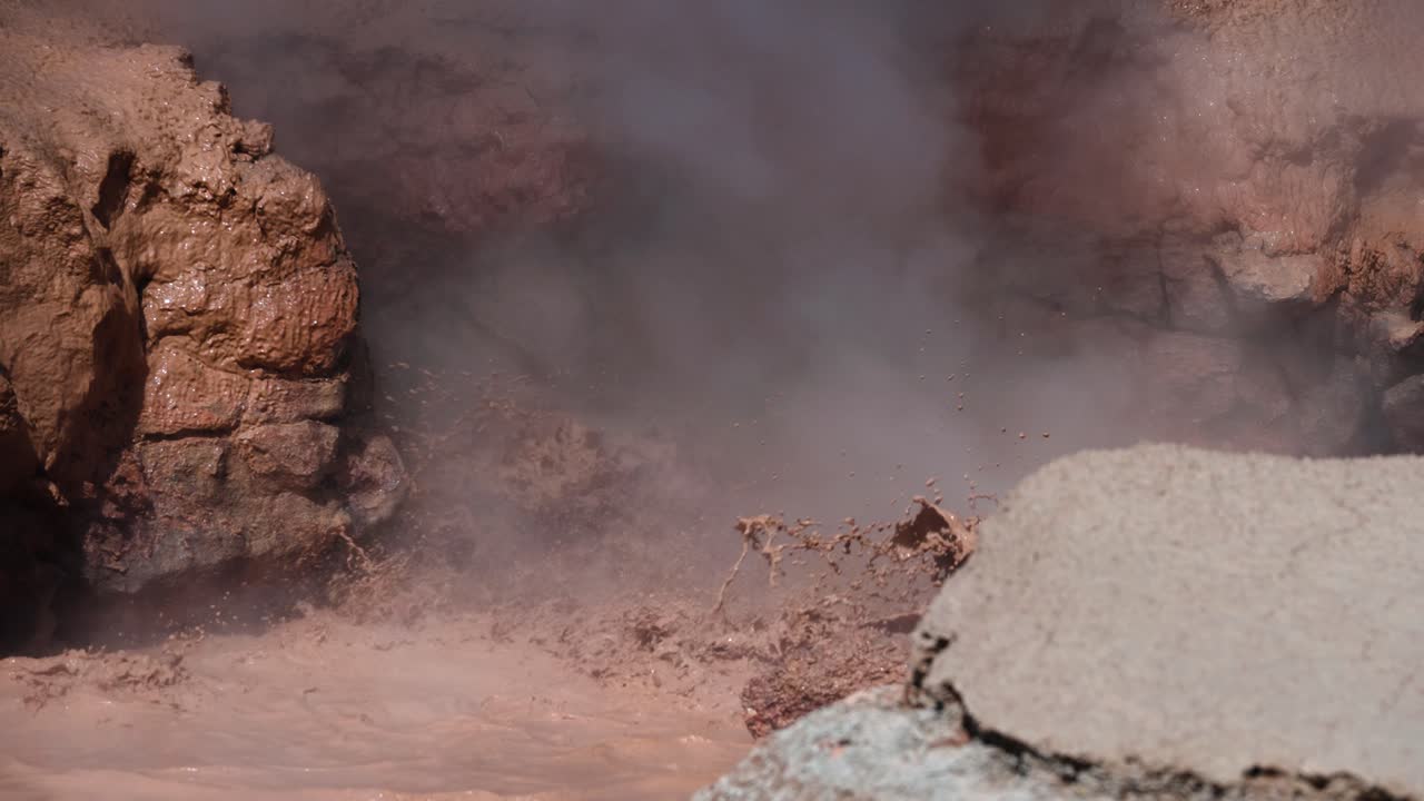 aguas termales geotérmicas naturales burbujeando y disparando agua fangosa marrón al aire en el parque nacional de yellowstone en cámara lenta