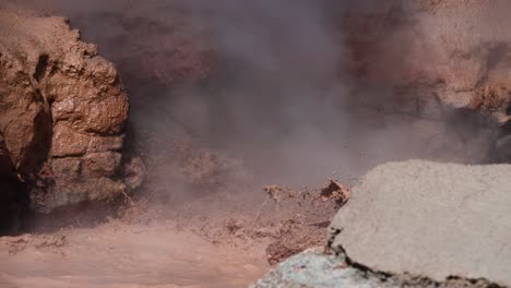 Natural-geothermal-hot-spring-bubbling-and-shooting-brown-muddy-water-into-air-at-Yellowstone-National-Park-in-slow-motion