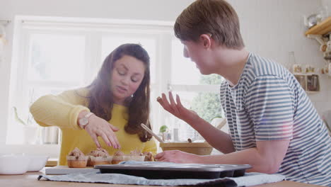 Pareja-Joven-Con-Síndrome-De-Down-Decorando-Pastelitos-Caseros-Con-Glaseado-En-La-Cocina-De-Casa