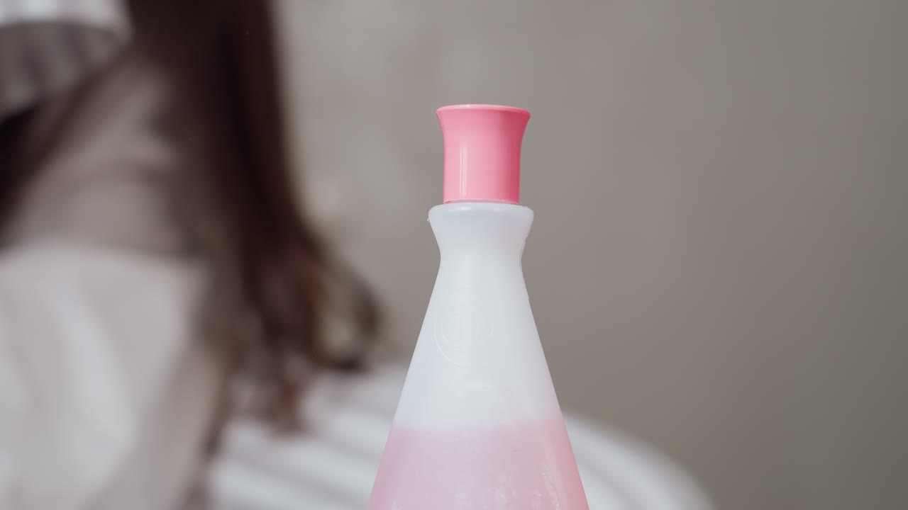 Student hand closes pink cap on nail remover bottle, careful twist after pedicure, soft indoor light, focus on hygiene and beauty routine, close view highlights grip, clean skin