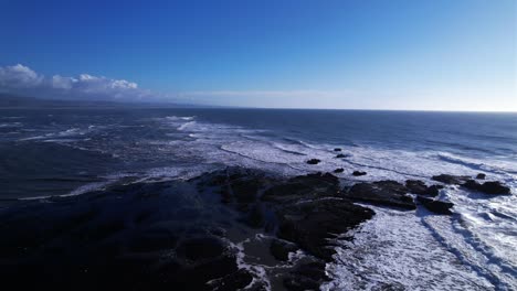 Drone-truck-left-over-incoming-tide-at-Mavericks-Beach,-California-during-sunset