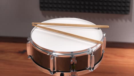 snare drum with drumsticks in a music studio