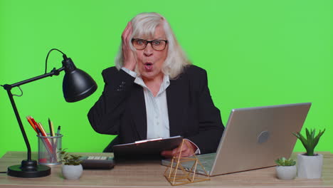 senior businesswoman analysing paperwork documents shocked by sudden win victory, good news, omg wow