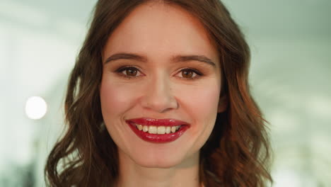 mujer joven con maquillaje profesional se ve en la cámara sonriendo