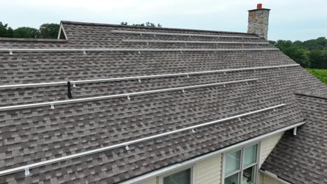 metal tracks on shingle roof prepared for solar panel array install