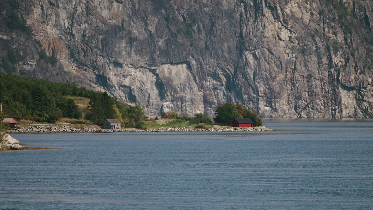 eidsdal 근처의 평화로운 해안선, geiranger fjord에, 가파른 절벽의 배경에 내장 된 오두막과 함께.