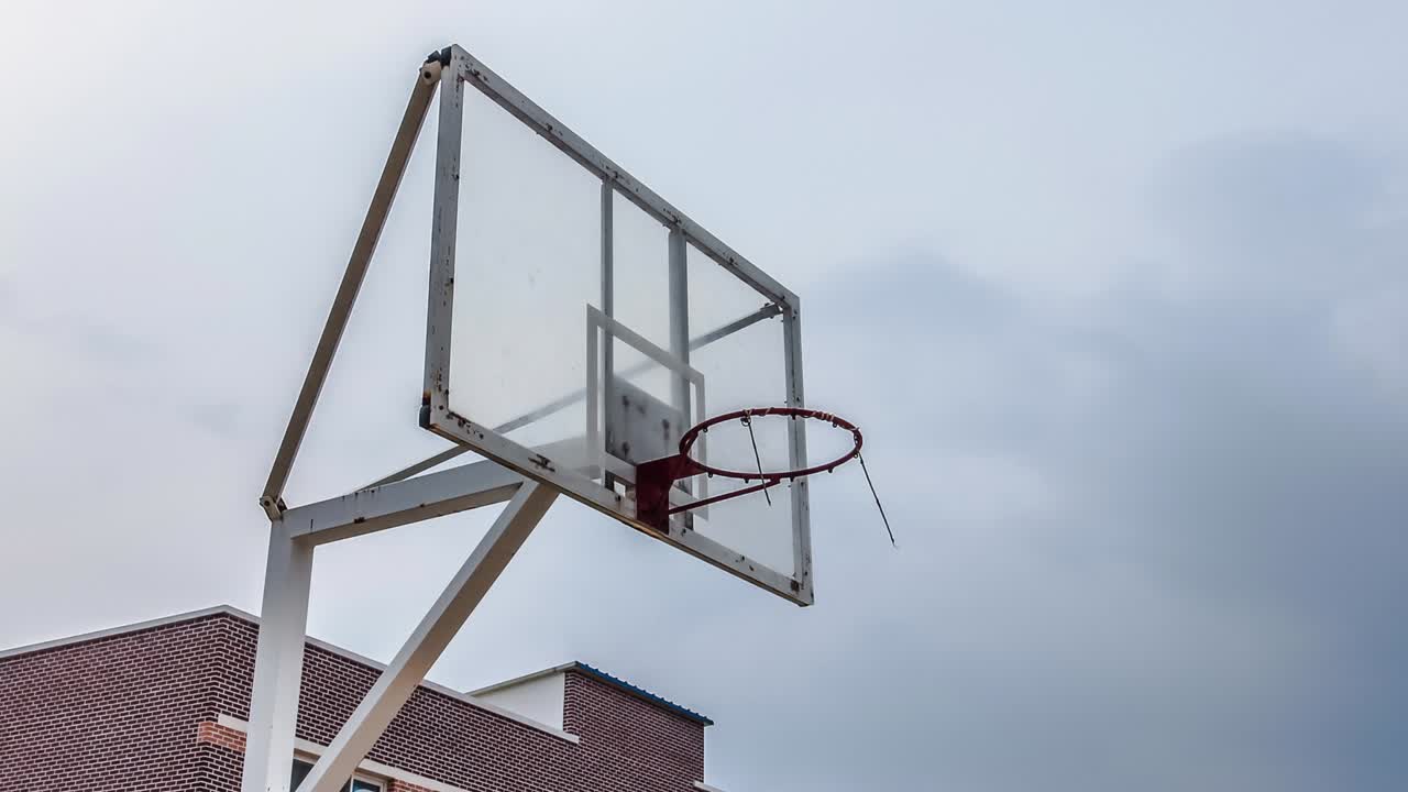 un ring de baloncesto en una escuela en asia con fondo nublado de lapso de tiempo