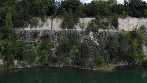 aerial view of a quarry tracking backward revealing lake with still water
