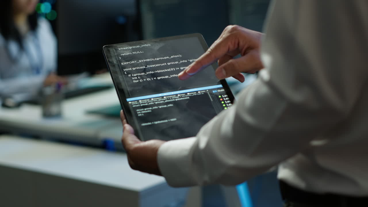 Programmer using device in data center, close up