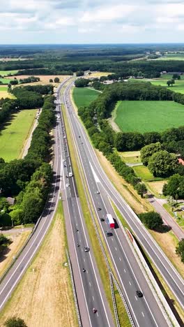 aerial view of a multi-lane highway with traffic surrounded by green fields