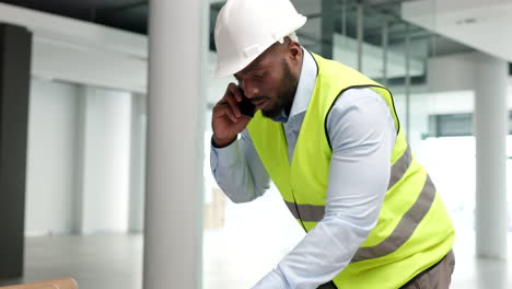 construction worker on a phone call in an empty office space