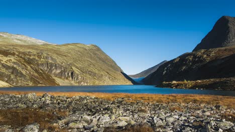 small lake in valley on top of mountain with clouds