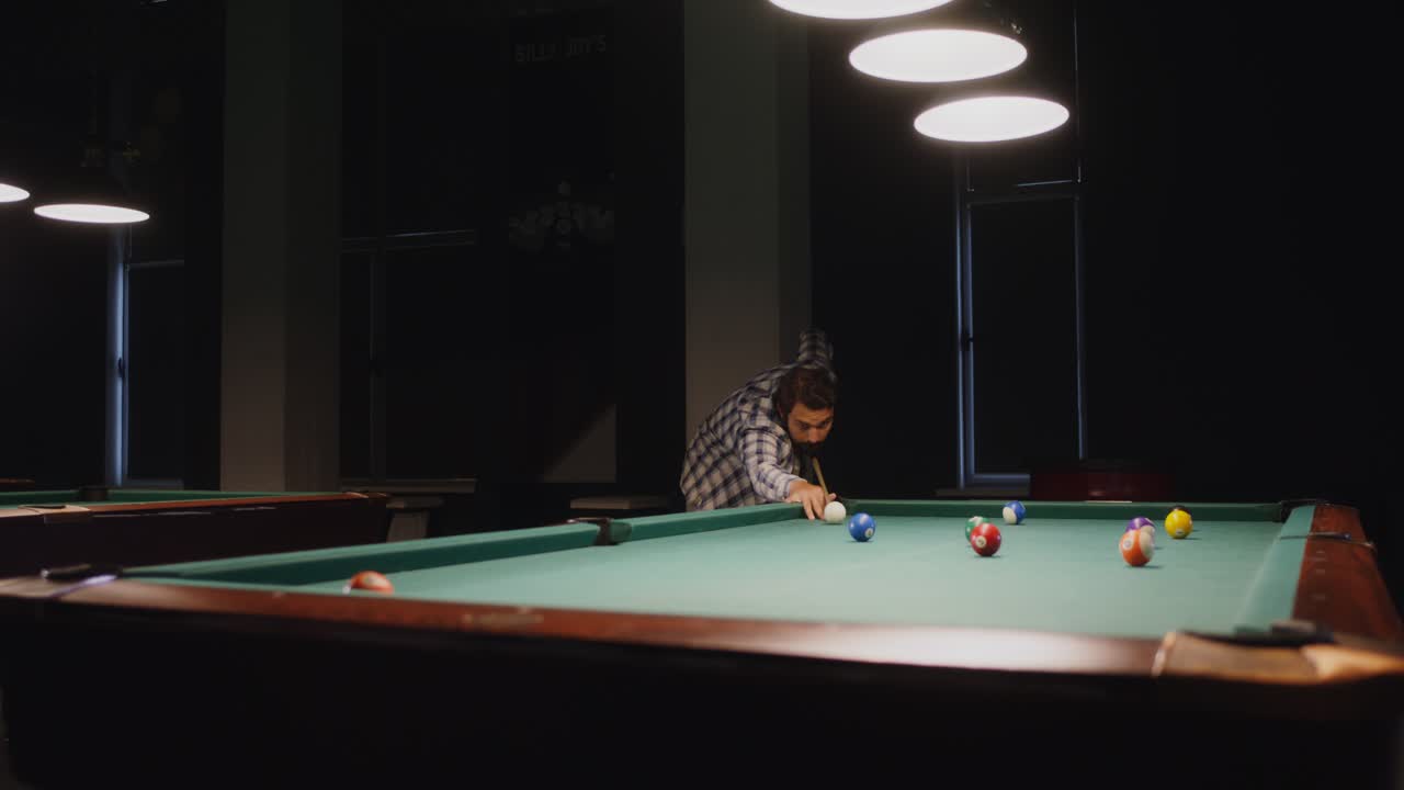 Man Playing Pool in a Dark Bar