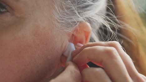 close up of senior woman using wireless earphones