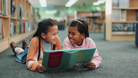 two girls reading a book in the library