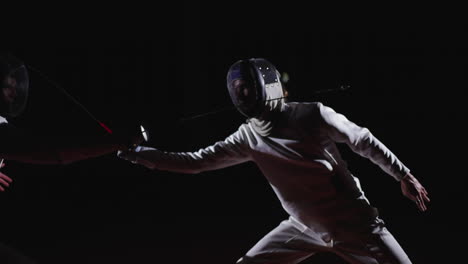 two fencers engaged in a competitive match