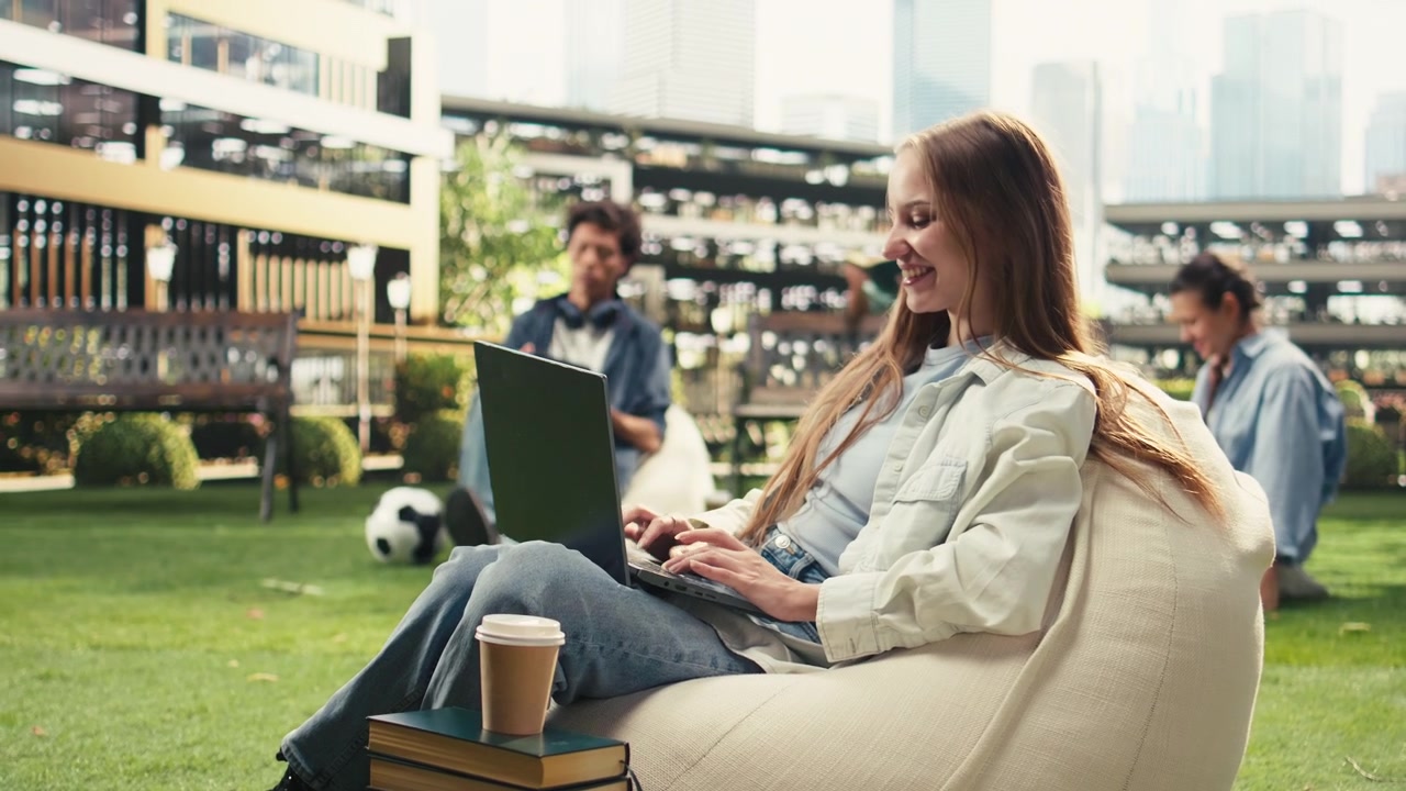 Studentessa che guarda lo schermo del laptop e digita nel campus