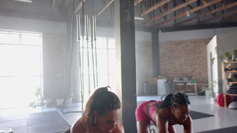smiling strong fit woman in gym wearing sportswear, standing next to exercising partner, copy space